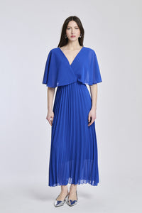 Un abito in bluette con lo stesso design crociato e maniche a mantello, creando un'atmosfera di serenità e vitalità.