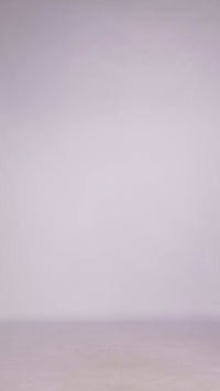 Donna con abito navy senza maniche, midi, nodo al petto, look elegante e classico.