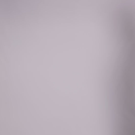 Donna con abito marrone senza maniche, midi, nodo al petto, look elegante e naturale.
