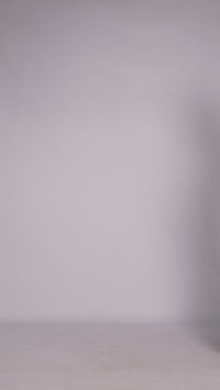 Donna con abito marrone senza maniche, midi, nodo al petto, look elegante e naturale.
