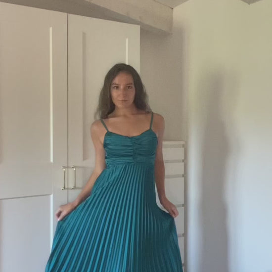 Donna con abito lungo blu a spalline sottili in ambiente domestico