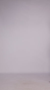 Donna con abito verde scuro elegante, collo alto a imbarcatura, gonna lunga, foulard in tulle trasparente, look elegante e misterioso.