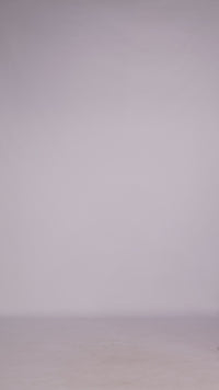 Donna con abito ciliegio senza maniche, midi, nodo al petto, look elegante e femminile.