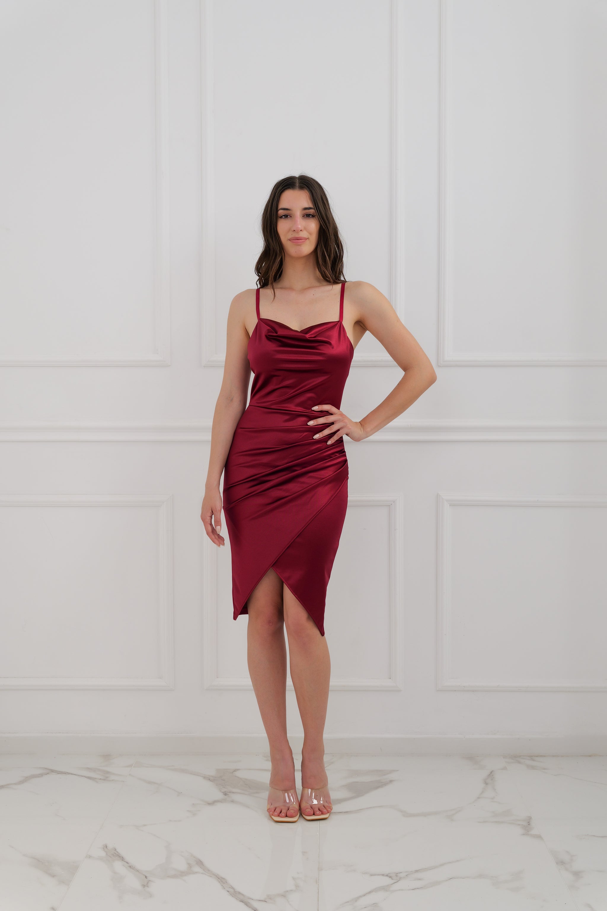 Questo abito in raso bordeaux, con design di spalline sottili e gonna asimmetrica, è l’ideale per trasformarti in una diva alle feste. Il suo taglio aderente esalta ogni curva, regalando un look sexy e raffinato. 