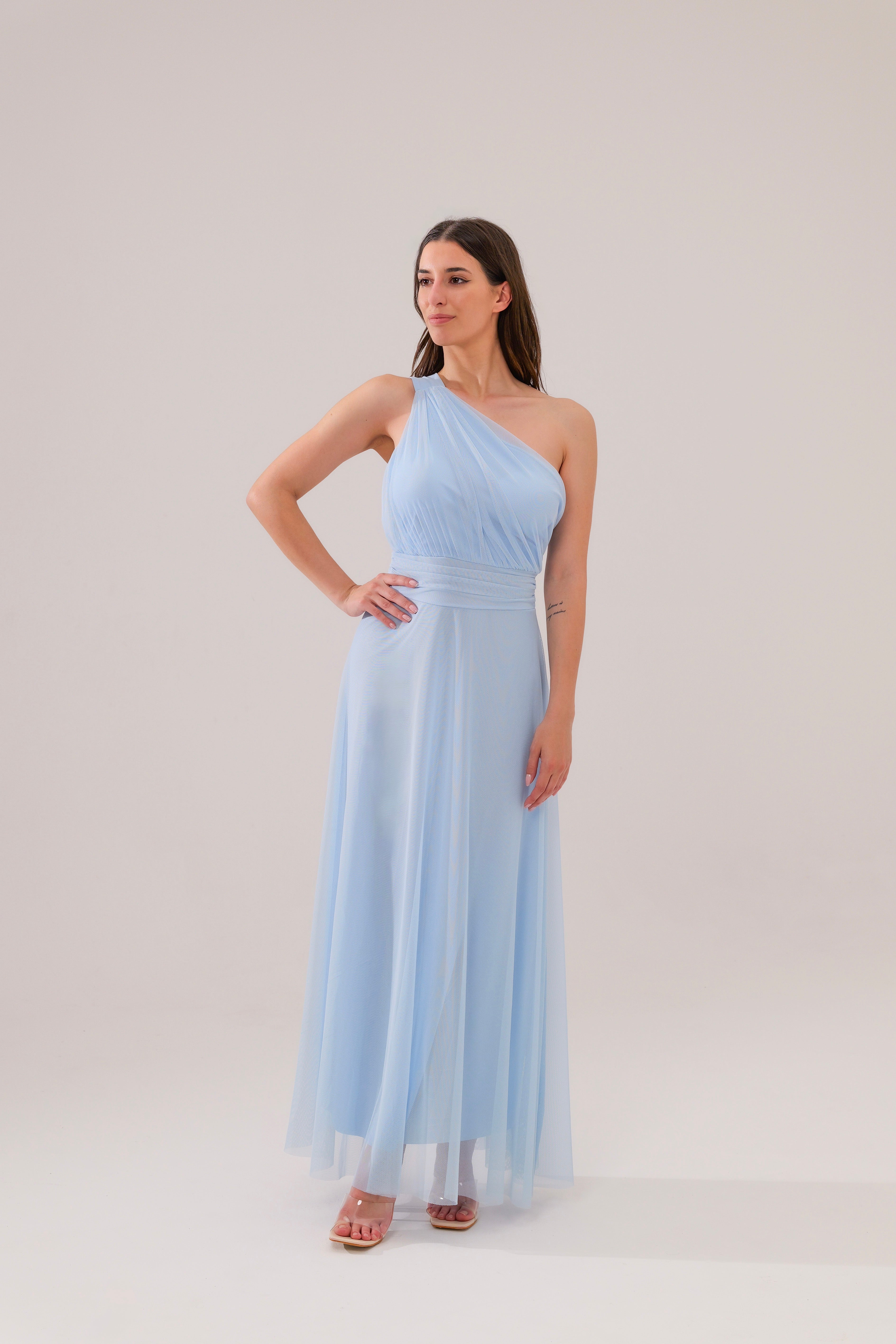 Questo abito celeste a spalla unica, in tulle leggero, è la definizione di eleganza eterea. Il taglio aderente al busto e la gonna fluida regalano un look da favola, perfetto per cerimonie o eventi esclusivi. 
