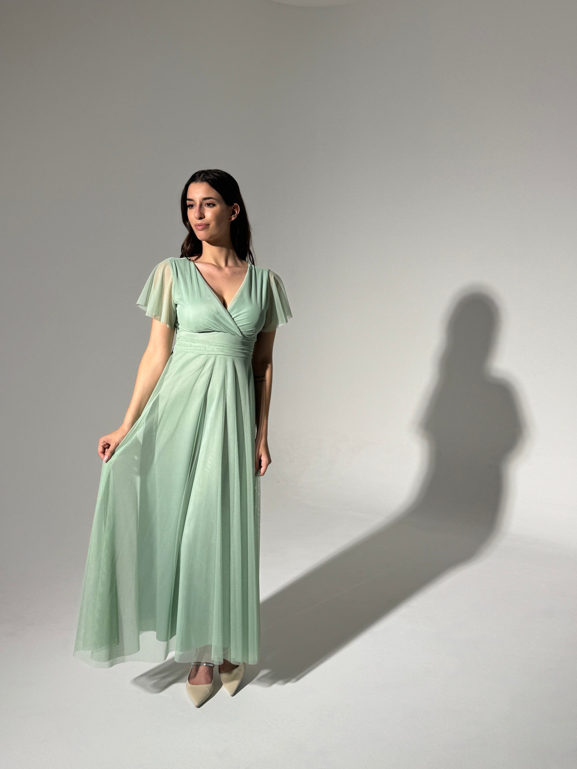 Donna in abito lungo verde menta, scollatura a V, maniche volanti in tulle trasparente