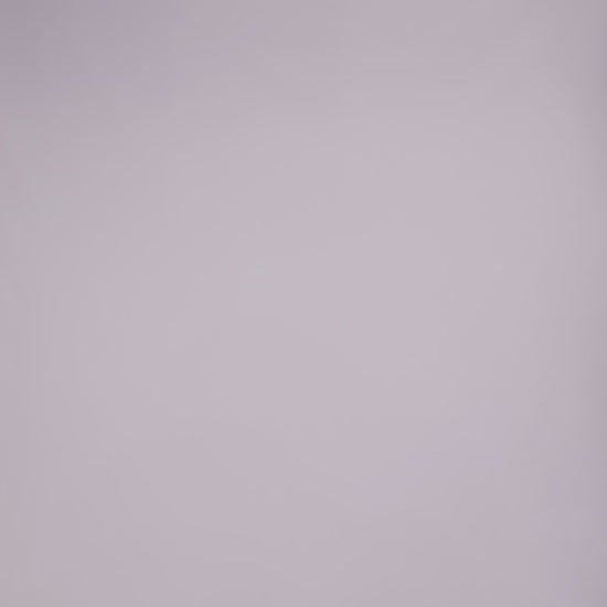 Donna con abito bordeaux senza maniche, midi, nodo al petto, look elegante e ricco.