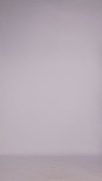 Donna con abito bordeaux senza maniche, midi, nodo al petto, look elegante e ricco.