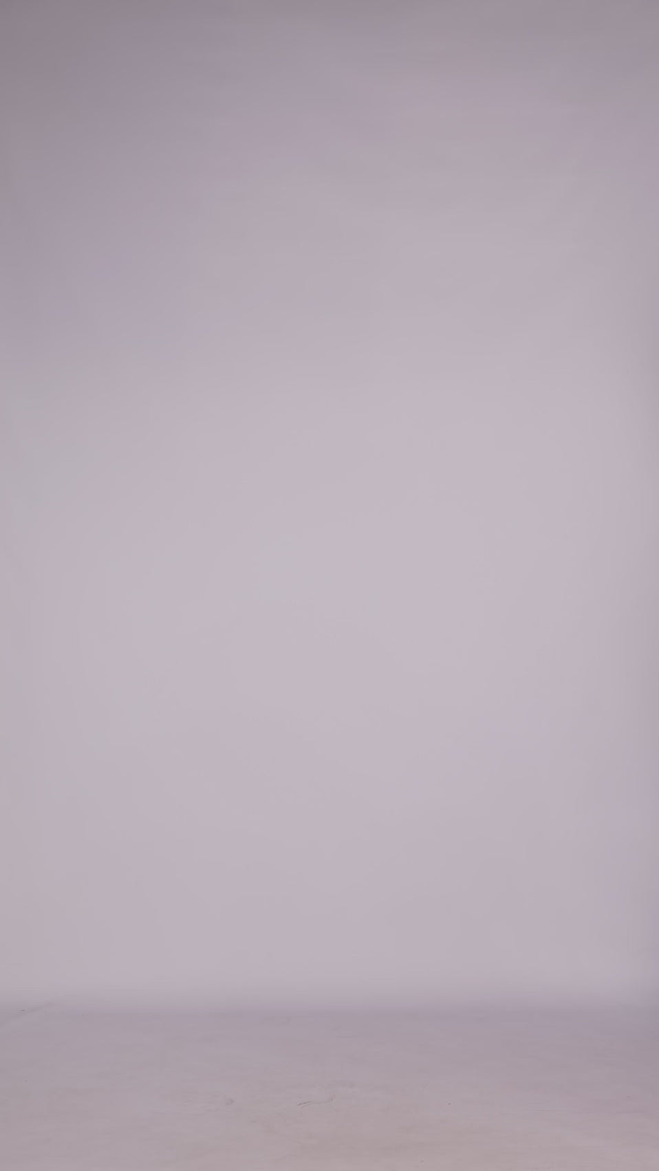 Donna con abito bordeaux senza maniche, midi, nodo al petto, look elegante e ricco.